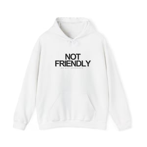 Könnte beinhalten: Weißer Kapuzenpullover mit Fronttasche und Kordelzug. Der schwarze Text auf der Vorderseite lautet "NOT FRIENDLY" über "DO NOT APPROACH". Ein lässiges, bequemes Kleidungsstück.