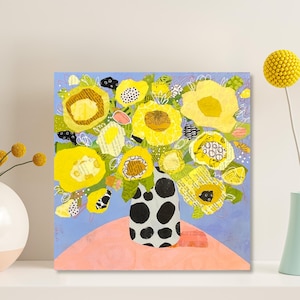 May include: A square art print featuring a bouquet of yellow flowers in a black and white polka-dot vase. The flowers sit on a pink surface against a light blue background. A single yellow flower is in a light blue vase.