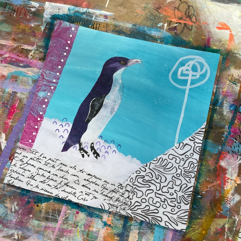 Puede incluir: Una obra de arte de t&eacute;cnica mixta que presenta un ping&uuml;ino pintado en tonos de azul, blanco y negro. El ping&uuml;ino est&aacute; de pie sobre un fondo blanco con acentos morados y azules. El fondo es azul claro con un dise&ntilde;o de c&iacute;rculo blanco. La obra de arte incluye texto escrito a mano en tinta negra.