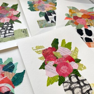 May include: A collage of paper flowers in a vase. The flowers are pink, red, and white, and the vase is made of paper and has a black and white pattern. The background is white.
