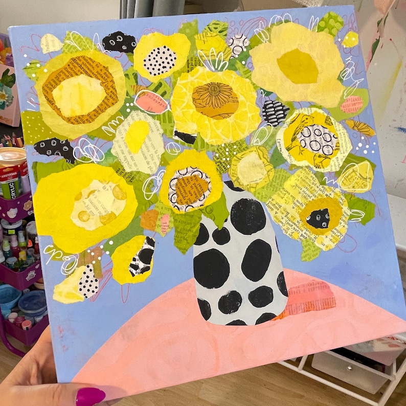 May include: An abstract painting of yellow flowers in a black and white polka-dot vase. The flowers are made of layered paper with text, set against a light blue background. A pink shape is at the bottom.