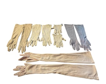 May include: A collection of eight pairs of gloves, including long and short styles. The gloves are in shades of white and light blue.