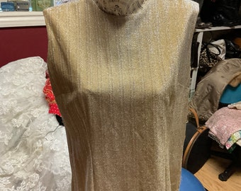 May include: A sleeveless gold metallic top with a round neckline. The top is on a mannequin and has a subtle shimmer.