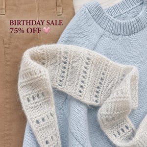 May include: A light blue knit sweater, a pair of tan trousers, and a cream-colored open-knit scarf. The text BIRTHDAY SALE 75% OFF is visible on the left side. The items are arranged together, showcasing the textures of the knit fabric and the fabric weave.