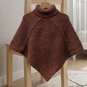 Peut inclure: Un poncho en tricot de couleur rouille doté d'un col roulé côtelé et d'un motif gaufré texturé sur le panneau avant. Le vêtement présente un ourlet pointu et est composé d'une combinaison de textures tricotées lisses et en forme de grille.