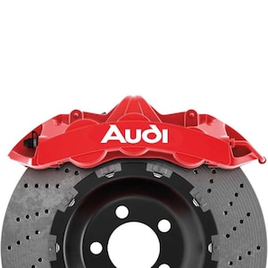 Pode incluir: Uma pinça de freio Audi vermelha com o logotipo Audi em texto branco é montada acima de um disco de freio perfurado preto e cinza. A imagem está em um fundo branco.