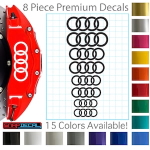 Pode incluir: Um conjunto de oito decalques premium com o logotipo da Audi em preto. A imagem também mostra uma pinça de freio vermelha com o logotipo da Audi e uma tabela de cores com 15 cores disponíveis. O texto diz "8 Piece Premium Decals" e "15 Colors Available!"