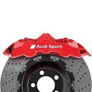 Pode incluir: Uma vista de perto de uma pinça de freio Audi Sport vermelha e um disco de freio perfurado. A pinça é vermelha brilhante com o logotipo Audi Sport em branco. O rotor é cinza com detalhes em preto e vários furos.