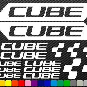 May include: A set of vinyl decals featuring the word CUBE in various sizes and styles, including two large slanted text blocks, several smaller text lines, and multiple square-based geometric logo icons, all displayed on a dark carbon fibre background.