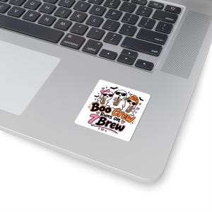 May include: A square sticker featuring three cartoon ghosts wearing sunglasses and holding iced coffee cups. The text reads "Boo Crew Runs on 7 Brew" in orange and black lettering with pink accents, small hearts, and bats surrounding the ghosts.