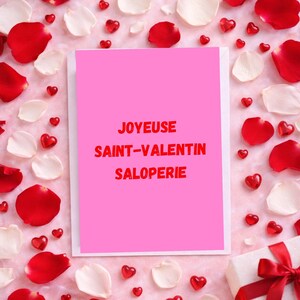 May include: A pink card with the text "JOYEUX SAINT-VALENTIN SALOPERIE" in red, surrounded by red and white rose petals, and heart-shaped decorations. A gift box with a red ribbon is in the bottom right corner.