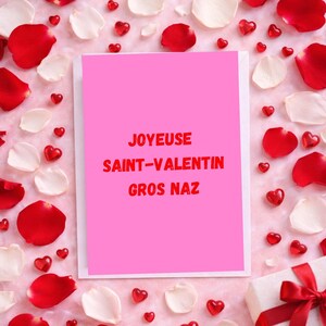May include: A pink greeting card with the text "JOYEUX SAINT-VALENTIN GROS NAZ" in red, surrounded by red and white rose petals, and heart-shaped decorations. A gift box with a red ribbon is in the bottom right corner.
