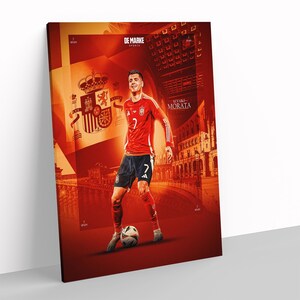 May include: A canvas print featuring a soccer player in a red jersey with the number 7, black shorts, and soccer cleats. The background is a collage of Spanish imagery, including a coat of arms and architectural elements. The print is titled "Alvaro Morata."