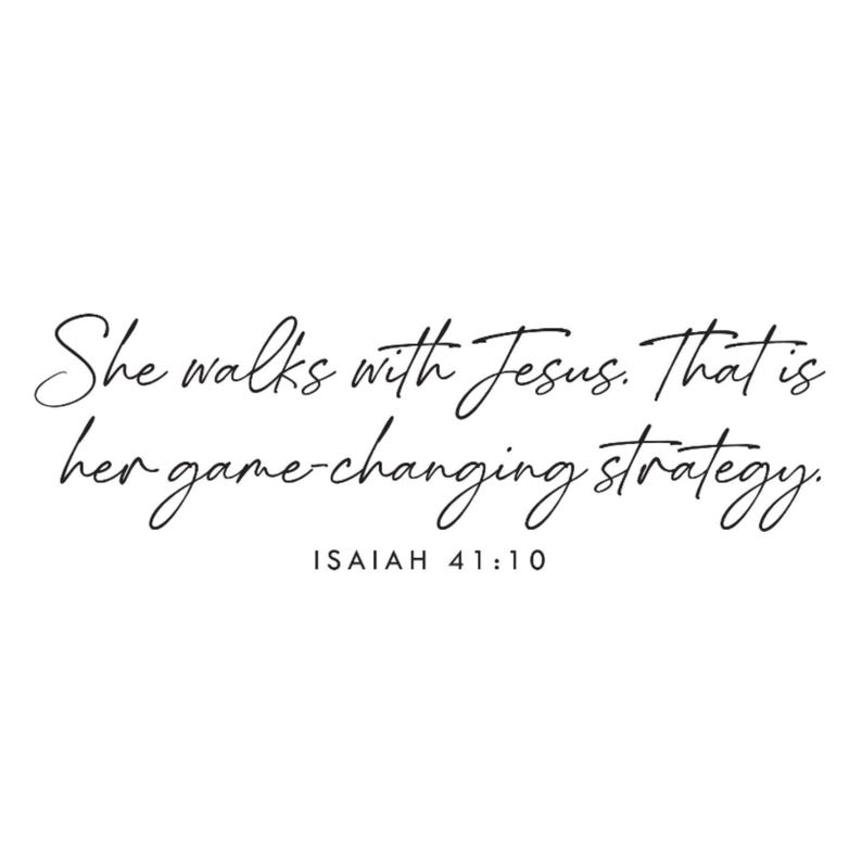 May include: White background with black cursive text that reads: "She walks with Jesus. That is her game-changing strategy." Below the text is "ISAIAH 41:10".