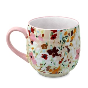 May include: A ceramic coffee mug with a floral pattern in shades of pink, red, orange, and white. The mug has a pink handle and a pink rim. The mug is approximately 4 inches tall.