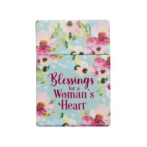 May include: A rectangular box with a floral design in pink, white, and yellow on a light blue background. The text "Blessings for a Woman's Heart" is displayed in pink script.