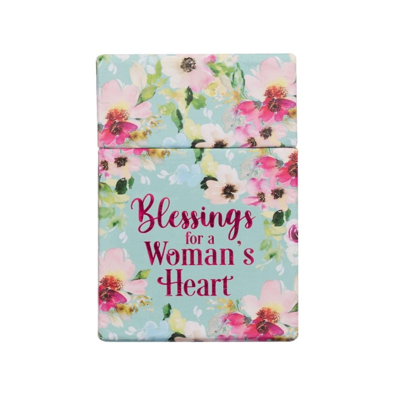 May include: A rectangular box with a floral design in pink, white, and yellow on a light blue background. The text "Blessings for a Woman's Heart" is displayed in pink script.