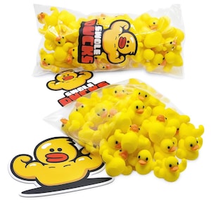 Puede incluir: Dos bolsas de plástico transparente llenas de patitos de goma amarillos. Una bolsa tiene la inscripción "SWOLE DUCKS", junto con un pato de dibujos animados flexionando sus músculos. También es visible una pegatina del mismo pato.