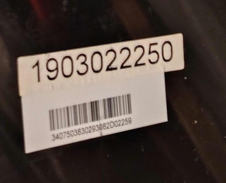 Może przedstawiać: Biała prostokątna naklejka z czarnym numerem "1903022250". Poniżej numeru znajduje się kod kreskowy i czarny numer "3407503830293062D02259".