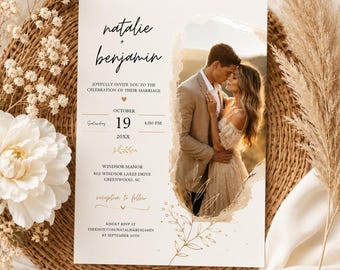 May include: A wedding invitation card featuring a photograph of a couple embracing. The text reads Natalie + Benjamin, joyfully invite you to the celebration of their marriage, October 19, 20XX, 4:00 PM, Windsor Manor, 802 Windsor Lakes Drive, Greenwood, SC.