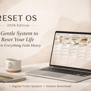 Puede incluir: Un portátil que muestra una interfaz de sistema digital, con el texto "RESET OS 2026 Edition" y "A Gentle System to Reset Your Life". Una taza de café, un cuaderno y un bolígrafo también están sobre la mesa. El sistema es un sistema Trello digital.