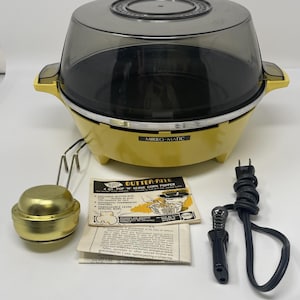 Puede incluir: Una máquina de palomitas Mirro-Matic 4 quart Pop 'N Serve amarilla con tapa translúcida oscura, una taza de mantequilla dorada, un cable de alimentación negro y un manual. La base muestra el nombre Mirro-Matic en texto negro sobre una etiqueta plateada.