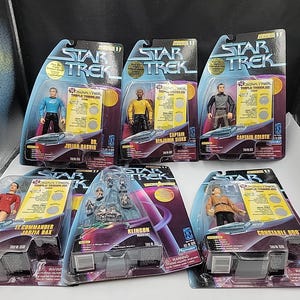 May include: Five Star Trek action figures in original blister packaging, including Dr. Julian Bashir, Captain Benjamin Sisko, Captain Koloth, Commander Jadzia Dax, and Constable Odo, plus a separate Klingon warrior figure set with multiple small pieces.
