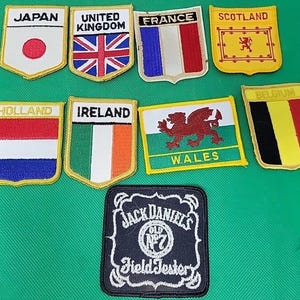 Peut inclure: Un ensemble de neuf écussons brodés représentant divers drapeaux nationaux dont le Japon, le Royaume-Uni, la France, l'Écosse, la Hollande, l'Irlande, le Pays de Galles et la Belgique, ainsi qu'un écusson noir avec le texte Jack Daniel's Field Tester.