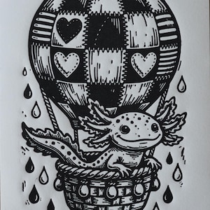 May include: Black and white illustration of an axolotl in a hot air balloon. The balloon has a checkered pattern with heart shapes. The axolotl is in a woven basket, with raindrops falling around it.
