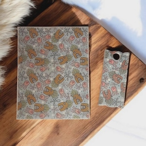 May include: A rectangular tile and a small cutting board with a repeating pattern of brown, green, and pink sea creatures on a light gray background. The cutting board has a hole for hanging.