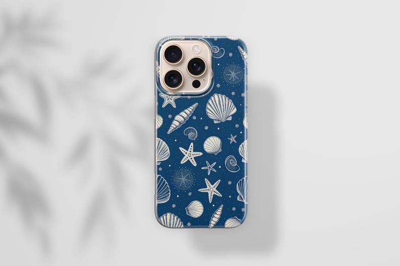 May include: A navy blue phone case featuring a pattern of white seashells, starfish, and nautical elements. The case has a clear border and is designed for a smartphone. The design includes various shell types and small dots.