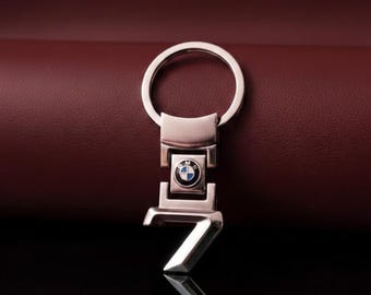 Llavero BMW Serie "7" Un llavero en tono plateado pulido que presenta un número "7" prominente y el logotipo redondo de BMW