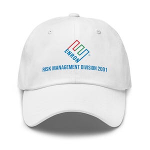May include: White baseball cap featuring the Enron logo in red, green, and blue, with the text "ENRON RISK MANAGEMENT DIVISION 2001" in blue. The cap has a curved peak and adjustable strap.