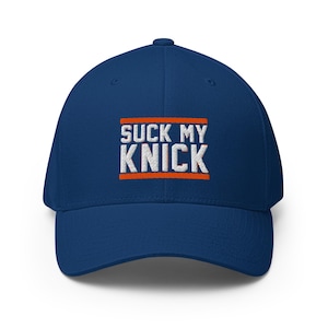 Könnte beinhalten: Eine königsblaue Baseballkappe mit weißem Sticktext, der SUCK MY KNICK lautet, zentriert zwischen zwei horizontalen orangefarbenen Sticklinien auf der Vorderseite. Die Kappe hat eine strukturierte Krone, einen gebogenen Schirm und einen Knopf.