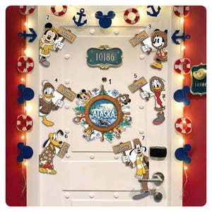 May include: A white door decorated with Disney-themed nautical decorations. The door features a central Alaska-themed wheel, character cutouts holding name signs, and decorative lights. The door number is 10186.