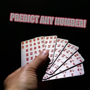 May include: A hand holds a fan of white cards with red numbers, against a black background. The cards are numbered from 1 to 63. The text "PREDICT ANY NUMBER!" is displayed above the cards.