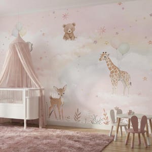 Peut inclure: Une fresque murale de chambre d'enfant illustrant à l'aquarelle un ours brun, une girafe tenant des ballons et un faon parmi des nuages et des étoiles. Un berceau blanc avec un baldaquin rose est à gauche, près d'une petite table et de chaises.