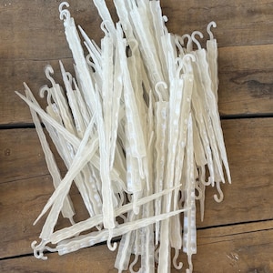 Könnte beinhalten: Ein Haufen transparenter, kunststoffener Eiszapfen-Weihnachtslichter mit Haken. Die Eiszapfen sind etwa 25 cm lang und haben eine strukturierte Oberfläche.