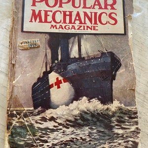 以下が含まれることがあります： 1915年1月発行のポピュラーメカニクス誌のヴィンテージカバー。表紙には、側面に赤い十字架が描かれた大型船が荒波の中を航海している白黒のイラストが描かれています。