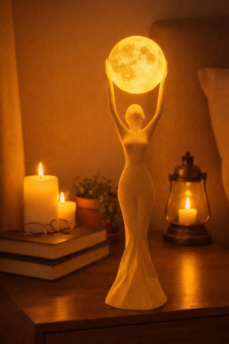 May include: A cream-colored sculpture of a woman holding a glowing moon-shaped light above her head. The lamp is on a wooden nightstand with candles, books, and a lantern. The overall theme is a warm, inviting ambiance.