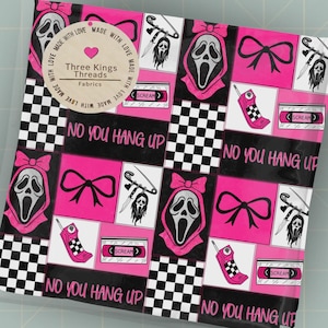 Puede incluir: Una pieza de tela cuadrada con un patrón repetitivo de lazos rosas y negros, máscaras de fantasma, teléfonos móviles antiguos, cintas de casete y imperdibles con cuchillos. El texto dice "NO YOU HANG UP" y "SCREAM". Una etiqueta circular dice "Three Kings Threads Fabrics".