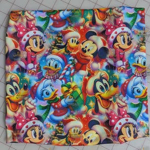 May include: A colorful fabric featuring a festive pattern with Mickey Mouse, Minnie Mouse, Donald Duck, and Pluto in holiday attire. The design includes Christmas trees, gifts, and candy canes, with a vibrant mix of red, blue, and green.