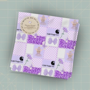 May include: A square fabric with a patchwork design in shades of purple and white. The design includes the Carhartt logo, bows, flowers, and a fairy-like figure. The fabric has the text "Three Kings Threads Fabrics".