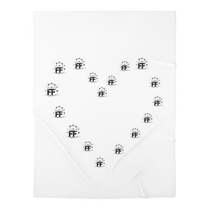 Op de afbeelding: Witte deken met een hartvormig patroon van zwarte berenillustraties, elk met de letters "FF". De deken is opgevouwen, waardoor hij een textuur krijgt.