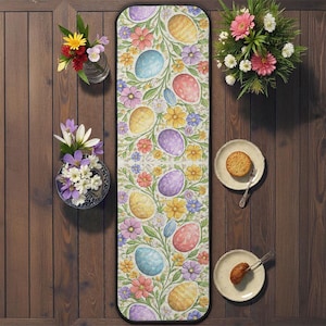 May include: A rectangular Easter-themed rug with a floral and egg design. The rug features colorful eggs, flowers, and green vines on a cream background. The rug is surrounded by wooden planks, vases with flowers, and plates with food.