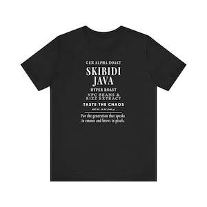 Può includere: T-shirt nera con testo bianco. Il testo recita: "GEN ALPHA ROAST SKIBIDI JAVA HYPER ROAST NPC BEANS & RIZZ EXTRACT TASTE THE CHAOS NET WT. 340 g Per la generazione che parla in emote e produce in pixel."