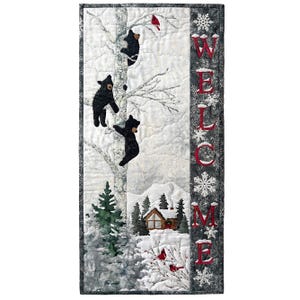 May include: A vertical quilted wall hanging featuring a winter scene with three black bears climbing a birch tree, a small cabin, and red cardinals. The word WELCOME is embroidered in red vertically along a dark gray snowflake-patterned border.