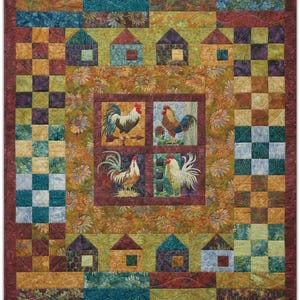 Könnte beinhalten: Ein Patchwork-Quilt mit Bauernhof-Thema. Der Quilt zeigt Quadrate, Häuser und Hahn-Bilder in Blau-, Grün-, Gelb- und Brauntönen. Der Quilt hat einen dunkelroten Rand und ein Blumenmuster.