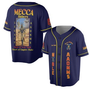 May include: Two navy blue baseball jerseys. One jersey features the text "MECCA Shriners" in gold, with an Anubis graphic and the text "LEGACY Oasis of New York Desert of Empire State". The other jersey has "Tour Noble" and "AAONMS" in gold.