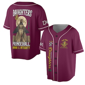 Könnte beinhalten: Burgunderfarbenes Baseball-Trikot mit weißem Besatz und Knopfleiste. Auf der Rückseite befindet sich eine Grafik einer Frau mit Kopfschmuck, der Text "DAUGHTERS PRINCEHALL HONOR & INTEGRITY 1910". Auf der Vorderseite steht "DAUGHTERS PRINCEHALL 1910" und "AZAH COURT".